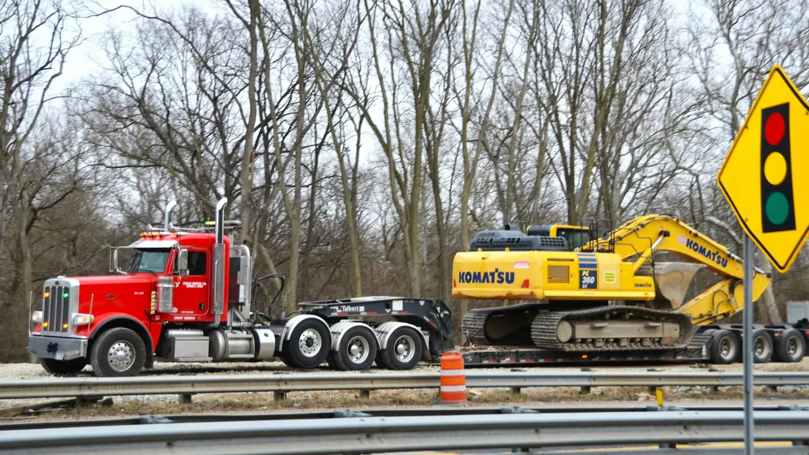 Step-deck truck hauling construction equipment